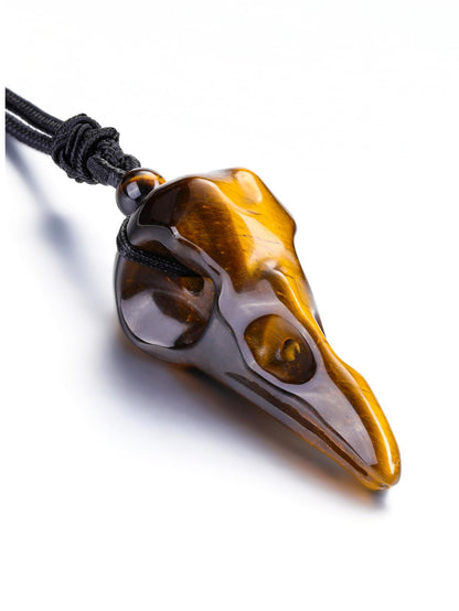 Carved tiger eye raven skull pendant necklace on a black cord